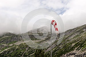 Red and white wind cone with mountains in the background