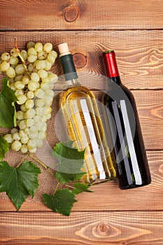 Red and white wine bottles and bunch of grapes