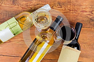 Red, white wine in bottles and glasses on rustic table