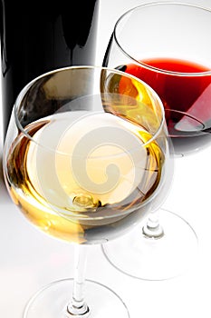 Red and white wine glasses with black bottle