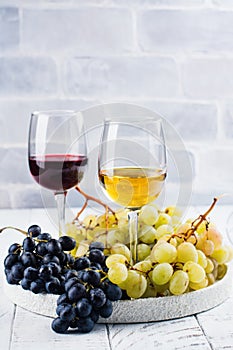 Red and white wine in glasses with grapes