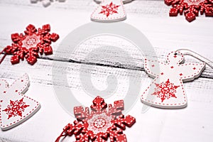 Red and white wooden snowflakes and angels for Christmas tree on white wooden table background