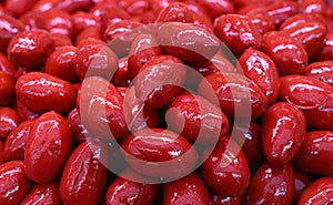 Red whole Cerignola olives in oil close up