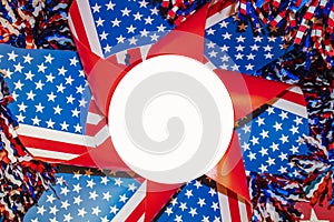 Red whte and blue pinwheel with stars and strips surrounded by tinsel with white circle for copy in center