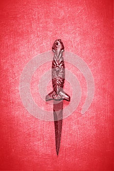 Red Wiccan dagger on a red background
