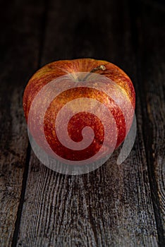 Red Wilted rotten apple on a wooden surface background