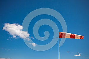 Red wind vane against a blue sky
