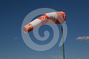 Red wind vane against a blue sky