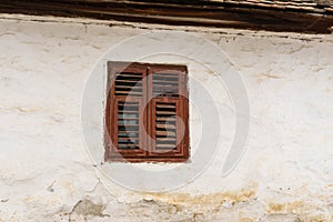Red window on old traditional Transylvanian log house