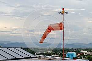 Red windsock inflated by the wind blows