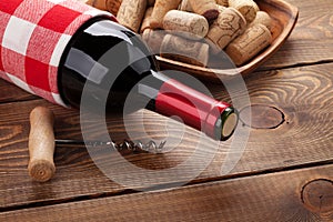 Red wine bottle, bowl with corks and corkscrew