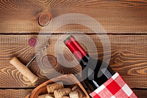 Red wine bottle, bowl with corks and corkscrew. View from above