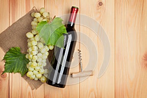 Red wine bottle and bunch of white grapes