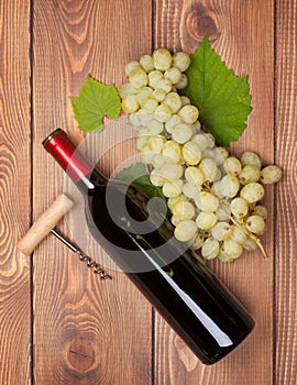 Red wine bottle and bunch of white grapes