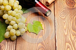 Red wine bottle and bunch of white grapes