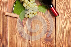 Red wine bottle and bunch of white grapes