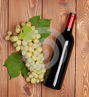 Red wine bottle and bunch of white grapes