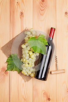 Red wine bottle and bunch of white grapes