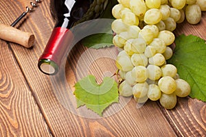 Red wine bottle and bunch of white grapes