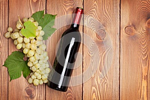 Red wine bottle and bunch of white grapes
