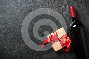 Red wine bottle and gift box on black background