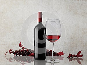 Red wine bottle glass bunch of grapes on marble background