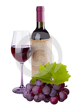 Red wine bottle, glass and grape with foliage on white