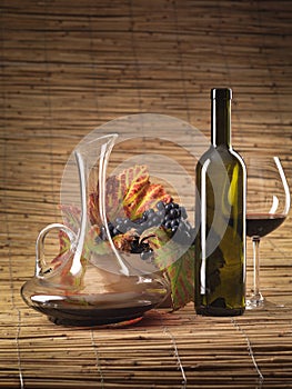 Red wine bottle, glass, grapes, decanter rustic