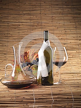 Red wine bottle, glass, grapes, decanter rustic