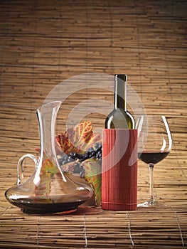 Red wine bottle, glass, grapes, decanter rustic