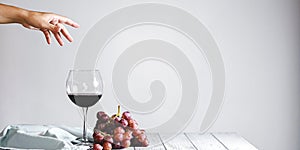 Red wine in a bottle, wine glass and red grapes over white background, isolated on white.