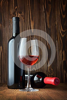 Red wine bottle and glass for tasting in cellar