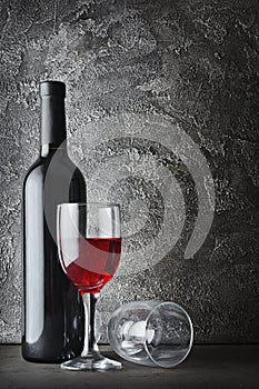 Red wine bottle and glasses for tasting in dark cellar