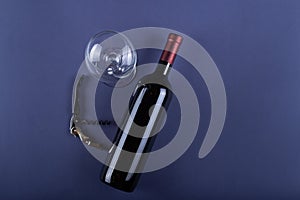 Red wine bottle without label, corkscrew and empty glass on purple paper background. Mockup drink with place for you label and