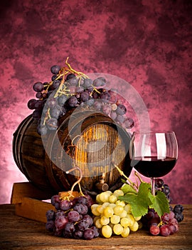 Red wine bottle and wine glass on wodden barrel