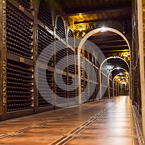 Red wine bottles stacked on wooden racks