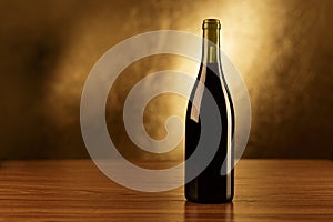 Red wine bottles wooden table and gold background