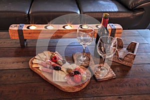Red wine with Charcuterie board on rustic wood with candles behind a spread of prosciutto panino