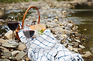 Red wine, cheese and bread served at a picnic