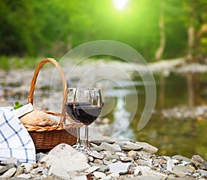 Red wine, cheese and bread served at a picnic