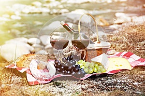 Red wine, cheese and grapes served at a picnic