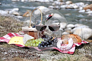 Red wine, cheese and grapes served at a picnic