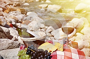 Red wine, cheese and grapes served at a picnic