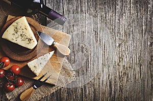 Red wine and cheese on rustic wooden board