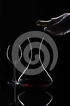 Red wine decanting process at isolated black