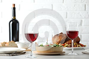 Red wine and delicious dinner served on light table