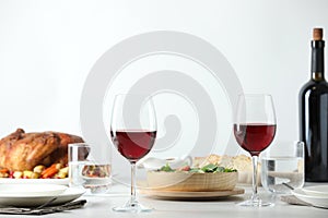 Red wine and delicious dinner served on light table