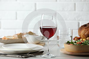 Red wine and delicious dinner served on light table