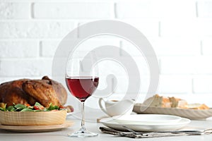 Red wine and delicious dinner served on light table