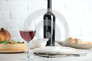 Red wine and delicious dinner served on light table